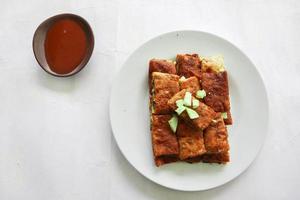 Martabak Telor or Murtabak Telur or mutabbaq. Savory pan-fried pastry stuffed with egg, meat and spices. Martabak Telur is one of Indonesia street food. photo