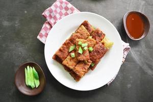 Martabak Telor or Murtabak Telur or mutabbaq. Savory pan-fried pastry stuffed with egg, meat and spices. Martabak Telur is one of Indonesia street food. photo