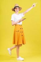 Full length photo of young Asian girl on yellow background