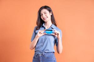 Young Asian business woman posing on orange background photo