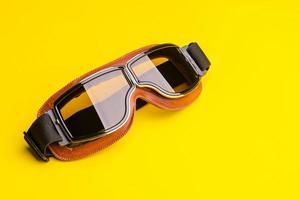 New brown vintage wind goggle. Studio shot isolated on yellow background photo