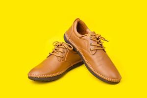 New brown men leather shoes. Studio shot isolated on yellow photo