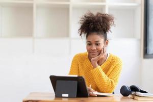 estudiante asiática en línea, clase de aprendizaje, estudio en línea, videollamada, profesor de zoom, niña asiática feliz, aprende inglés en línea con una computadora portátil. foto