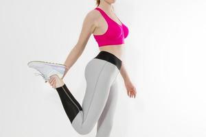 joven deportista con ropa deportiva aislada de fondo blanco. concepto de cuerpo de mujer de pérdida de peso feliz. cuerpo atlético y actividad adulta. copie el espacio entrenamiento de rodilla bandera foto