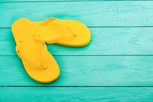 Yellow flip flops on blue wooden background. Summer holidays. Top view. Mock up. Copy space