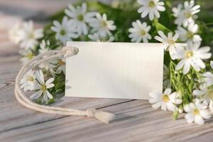 White flowers and blank white card for text. Mockup tag. Postcard photo