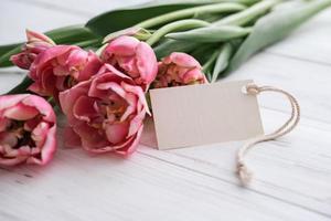 ramo de tulipanes rosas y maqueta de etiqueta para texto sobre fondo blanco foto