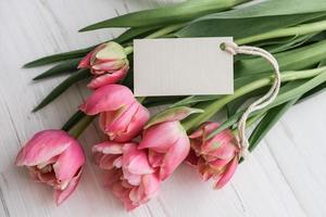 ramo de tulipanes rosas y maqueta de etiqueta para texto sobre fondo blanco foto