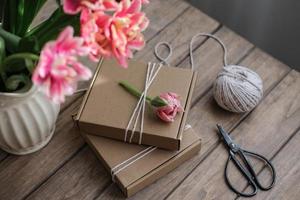 Kraft gift boxes decorated with flowers. Preparation of gifts. Gift wrapping idea photo