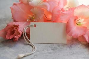 Bouquet of flowers and blank white card for text. Mockup tag. Postcard photo