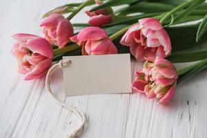 ramo de tulipanes rosas y maqueta de etiqueta para texto sobre fondo blanco foto