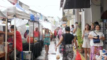 su di messa a fuoco sfocato di gli acquirenti shopping nel a piedi strada attraverso asiatico strada mercato nel talang strada, vecchio cittadina, Phuket Tailandia, sfondo video