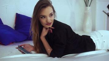 slender  girl lies in boots on the bed and makes a photo on your phone video