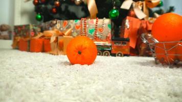 mandarins are falling on the floor near a Christmas tree video