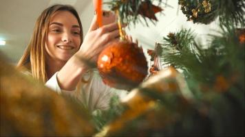 hermosa niña decora un árbol de navidad en la víspera de año nuevo video