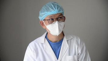 Porträt eines asiatischen Arztes, der glücklich darüber nachdenkt, die Lösung eines Problems zu finden