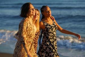 jóvenes novias diversas caminando cerca del mar foto