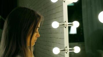 magnifique jeune fille met un rouge à lèvres devant un miroir à la maison en 4k video