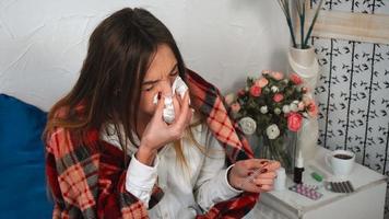 sick girl with sniffles and thermometer in hand at home video