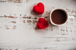 coffee Cup and red hearts on a white wooden background. Valentine's day. Place for text, place for copying. photo