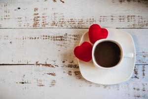 Red hearts and a Cup of coffee on a white wooden background. photo