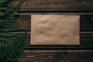 Frame from fern leaves on wooden background with copy space. Place for text. photo