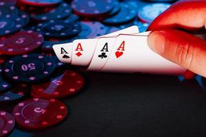 men's hands hold cards , a set of aces on the background of playing chips photo