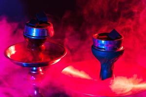 hookah bowl and coals close up on a black background with smoke photo