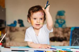 cute little boy holding colored pencils and markers photo