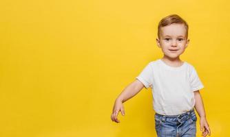 Laughing little boy on a yellow background. Copy space. photo