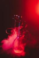 modern hookah, shisha on a smoky black background with neon lighting photo