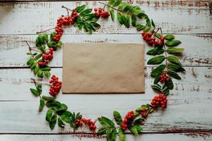 White wooden background with autumn rowan berries and leaves. Flat lay, top view photo