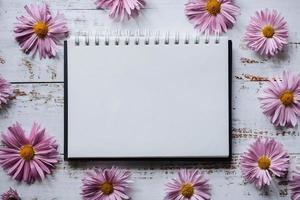 pink flowers frame, white wood background with copy of space photo