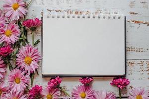 pink flowers frame, white wood background with copy of space photo