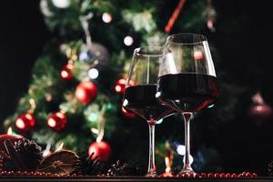 Glasses of wine on the background of a decorated Christmas tree. New Year photo