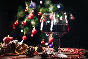 Glasses of wine on the background of a decorated Christmas tree. New Year photo