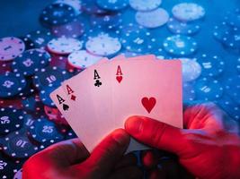 men's hands hold aces cards against the background of playing chips. the photo shows smoke