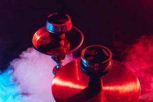 hookah bowl and coals close up on a black background with smoke photo