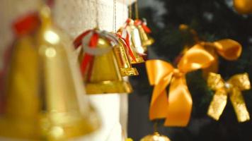 young girl with beautiful manicure touch a golden Christmas Bells at home video