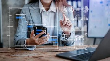 Businessman hand Project manager working and update tasks and Gantt chart scheduling virtual diagram.with smart phone, tablet and laptop photo