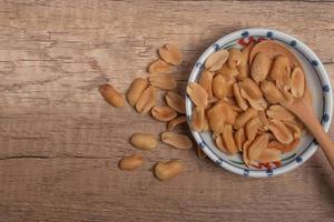 Peanuts in a cup on wooden background photo