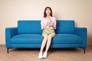 Image of young Asian woman sitting on sofa photo