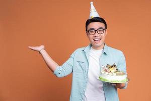 joven asiático sosteniendo pastel de cumpleaños foto