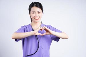 Portrait of young Asian nurse on white background photo