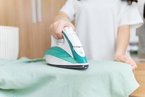 Young Asian woman ironing clothes photo