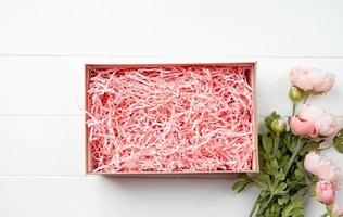 Shredded pink paper packing material texture in a craft box, mockup design photo