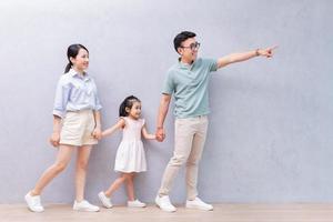 Young Asian family standing on background photo