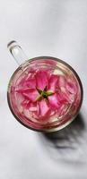 Rosa chinensis flower in glass cup filled with water, romantic concept illustration photo