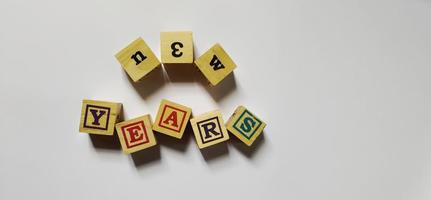 New years word in wooden cubes concept, isolated on white background. photo