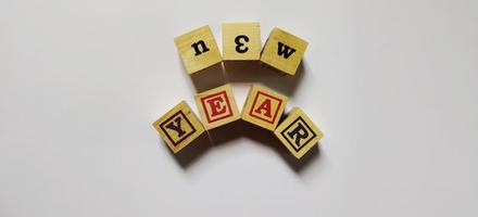 New year word in wooden cubes concept, isolated on white background. photo